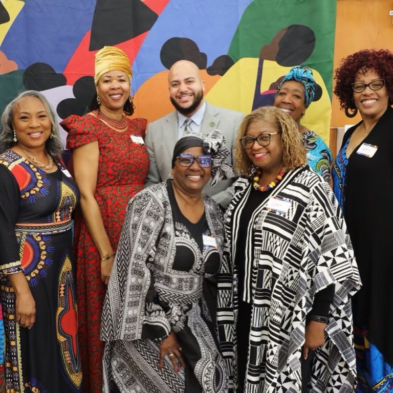 Isaac Bryan with community leaders in front of a mural