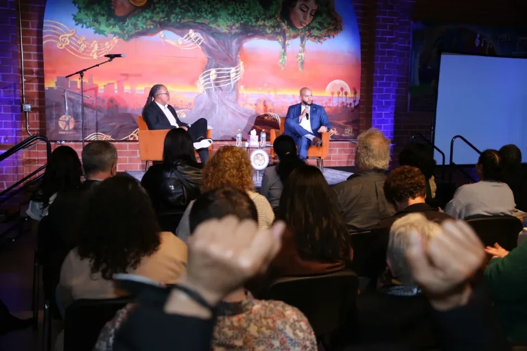 Isaac Bryan in conversation on stage at a community forum