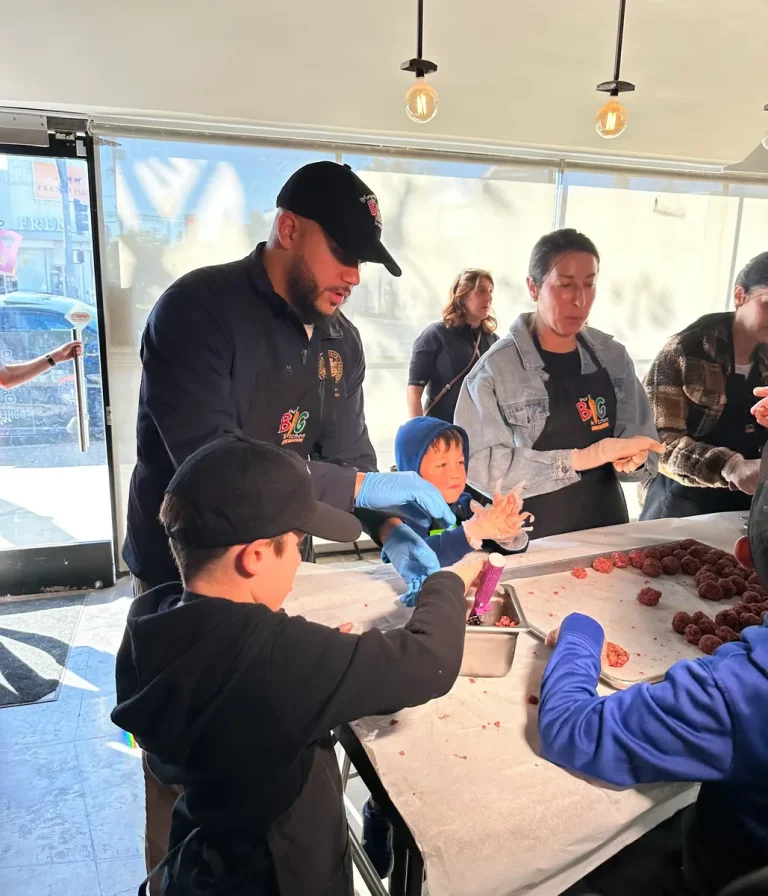 Isaac Bryan serving food with volunteers and children