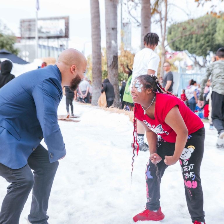 Isaac Bryan talking with a young girl at a community event